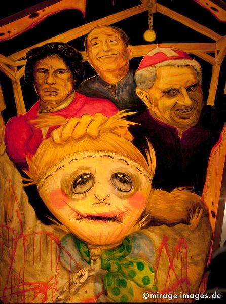 Muammar Abu Minyar al-Gaddafi
Schlüsselwörter: Laterne, Kirche, Religion, Frauen, Muammar al-Gaddafi, Kritik, Verstrickung, Basler Münster, beleuchtet, Ausstellung, Sarkasmus, Ironie, Fasnacht, kunstvoll, Cliquen, Sujet, Thema, Cortèges, Brauch, Tradition, Umzug, Humor, Comic, 