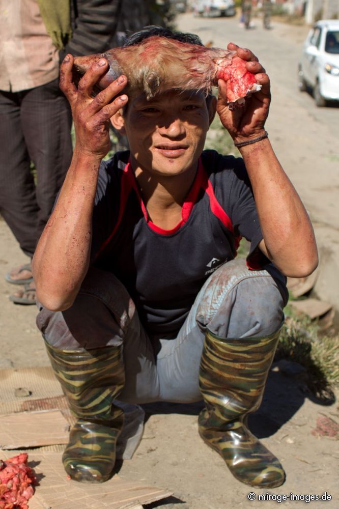 Young man offering a bloody Hoof of a Yak 
West Kamen Dirang
Schlüsselwörter: Fleisch ErnÃ¤hrung rot roh VerkÃ¤ufer KÃ¤ufer Tradition Yak Yakfleisch Hygiene Sonne Personen Verkauf Fleischer schlachten Farbe Mann draussen Tier Tod Huf tot unhygienisch verderben Blut blutig Einheimischer archaisch Alltag Handel Rind animalisch Markt